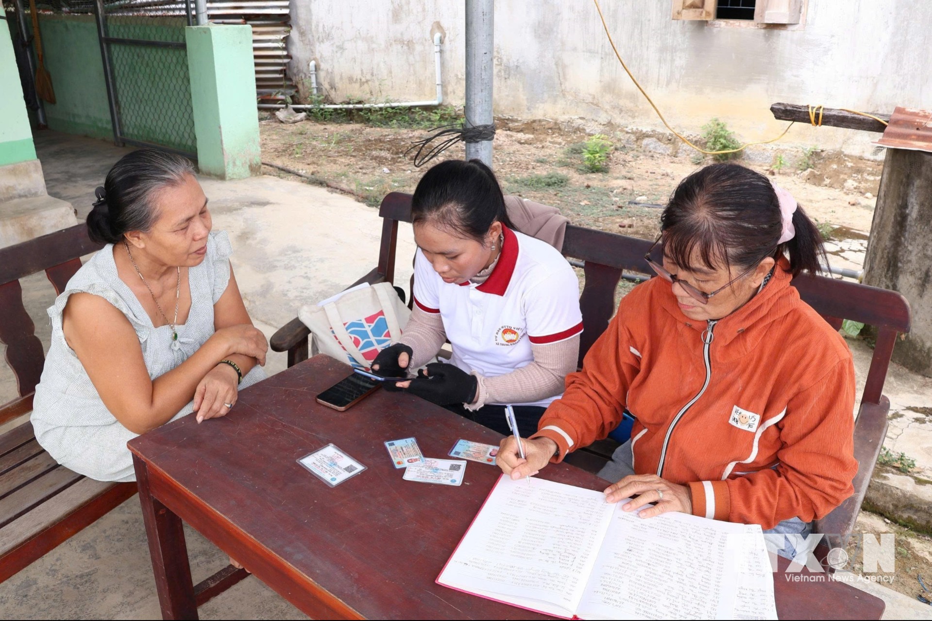 Cán bộ Trung tâm Phục vụ hành chính công xã Trung Khánh Vĩnh hướng dẫn trực tiếp giúp đồng bào dân tộc thiểu số tiếp cận thuận lợi với dịch vụ công trực tuyến. (Ảnh: Đặng Tuấn/TTXVN)